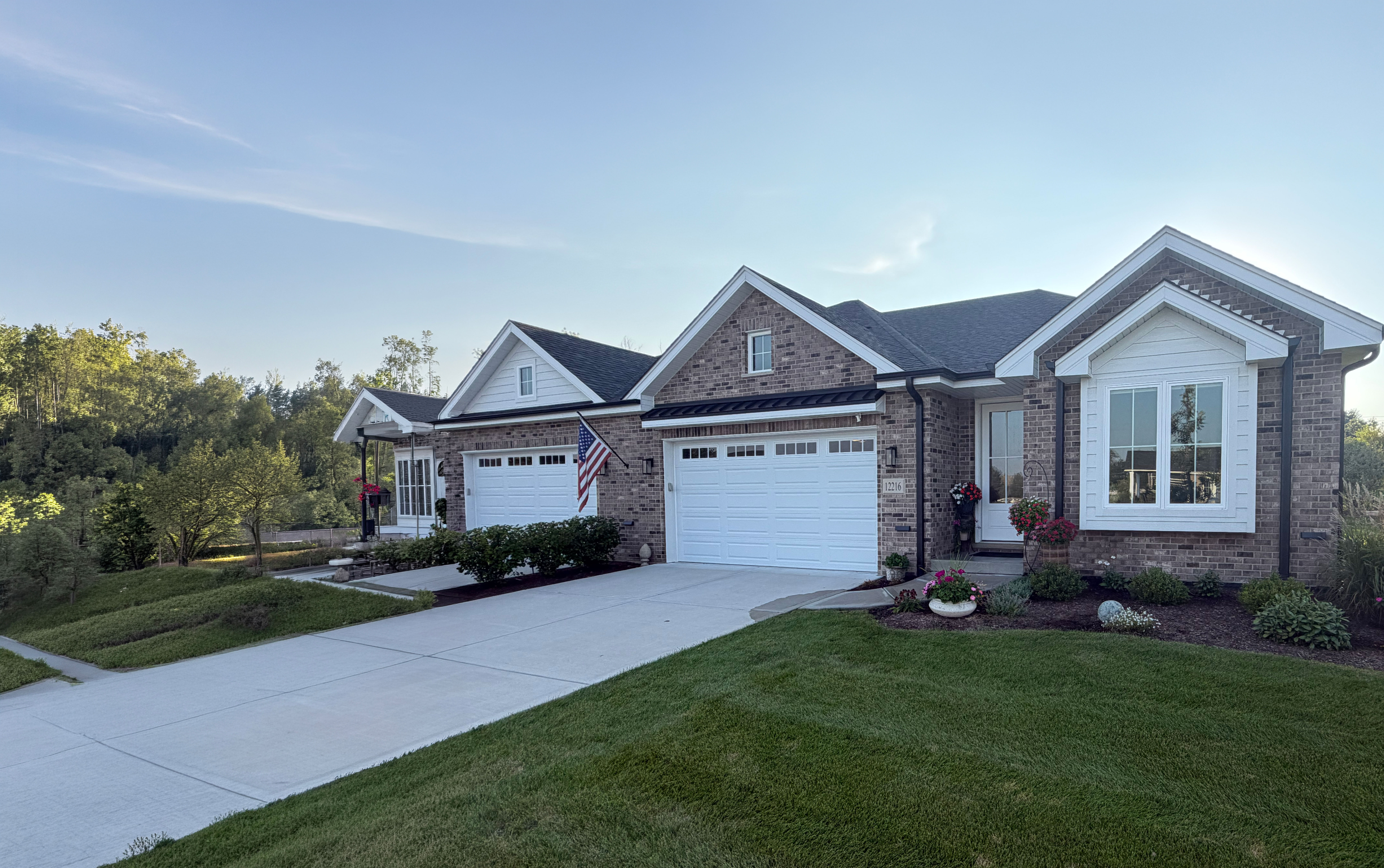 A brick single-family home with a two-car garage and landscaped front yard, representative of the Villas of Equestrian Meadows community
